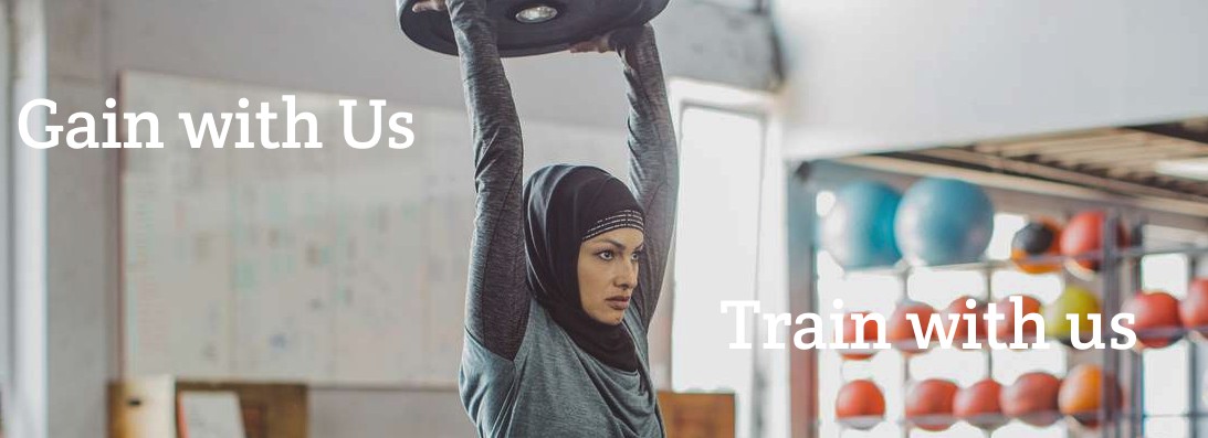 woman in hijab lifting weight plate.