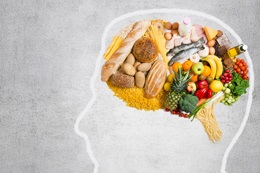 Image of outline of a person's head with an assortment of fresh food inside the head in the shape of a brain.
